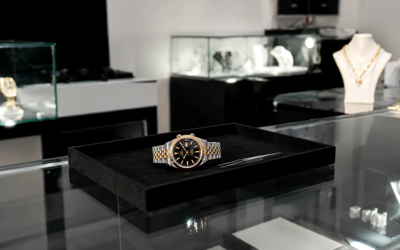 Reloj de acero y oro presentado en bandeja